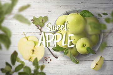 Fresh green ripe apple in bowl laying on wooden white table, and defocused leaves in front