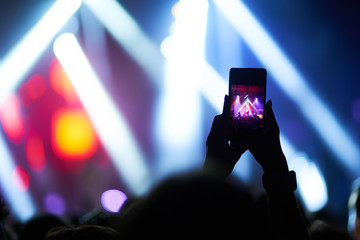 Fototapeta na wymiar Use advanced mobile recording, fun concerts and beautiful lighting, Candid image of crowd at rock concert, Close up of recording video with smartphone, Enjoy the use of mobile photography.