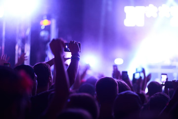 Use advanced mobile recording, fun concerts and beautiful lighting, Candid image of crowd at rock concert, Close up of recording video with smartphone, Enjoy the use of mobile photography.