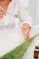 Woman preparing an aloe vera gel recipe with essences. Healthy, natural and cosmetic concept