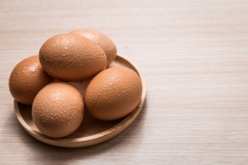 Close-up view of chicken eggs on wooden table background