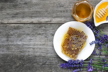 Honey with lavender flowers and honeycombs on rustic wooden table. healthy food. top view