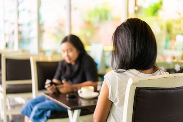 Happy asian woman relaxing use smartphone and chat with friend in cafe
