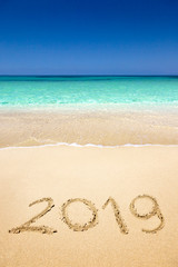 2019 written on sandy beach