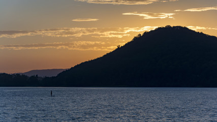 Sunshine the other side of horizon. Dusk above the lake. Evening nature by lake. Silhouette of horizon.