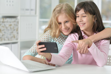 Fototapeta na wymiar Portrait of two girls with phone and laptop