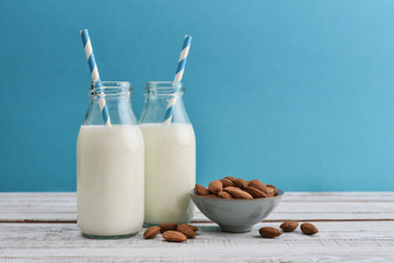 Almond milk in bottles with almonds