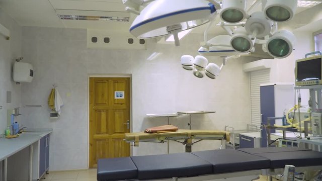 Operating room at hospital with equipment and medical devices. Table for surgical operations in the hospital. Interior of operating room in modern clinic.