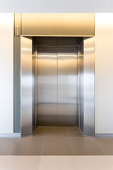 Modern steel elevator cabins in a business lobby or Hotel, Store, interior, office,perspective wide angle. Three elevators in hotel lobby.