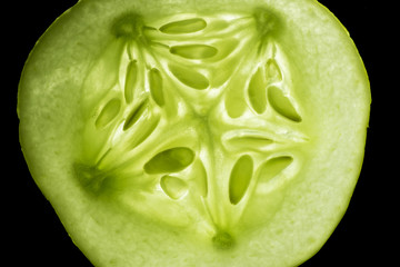 Macro photo of an illuminated lemon cucumber slice.