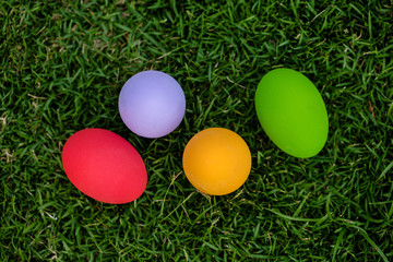 Fototapeta na wymiar Colorful Easter eggs background. holiday, easter background. Colorful easter eggs on the green garden yard. symbol of easter's day festival. vivid color natural background. festive wallpaper.