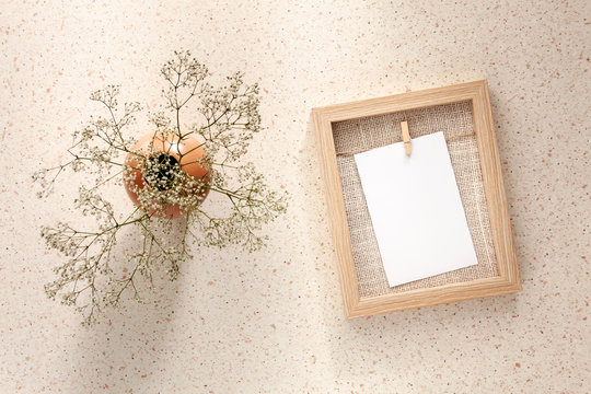 Photo Of Terrazzo Desk With Wooden Mockup Frame And White Flowers In A Vase