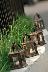 Obraz premium Wooden candlesticks at the road along the pedestrian path near the lawn