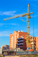 Construction of residential multi-storey houses with a crane in the foreground