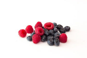 Blueberries and raspberries on white background.