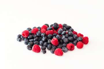 Blueberries and raspberries on white background.