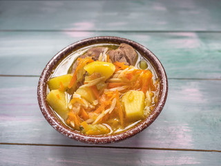 Hot soup in a deep ceramic brown bowl