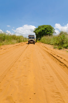 Vintage 4x4 Car Driving On Sandy Red Dirt Road In Countryside Of Democratic Republic Of Congo