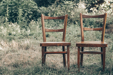 Fototapeta na wymiar Wooden chair, wooden chair twin, Pair old wooden chair outdoors. Around the lush grass, The environment offers privacy.