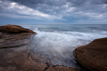 Seascape during sunrise. Beautiful natural seascape, blue hour. Sea sunrise at the Black Sea coast. Magnificent sunrise with clouds and fire sun in the middle of December.Ravda, Bulgaria