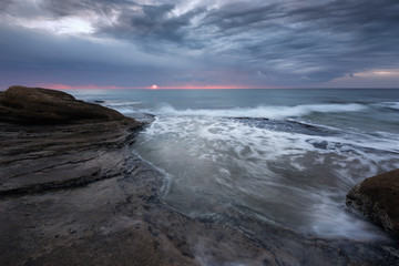 Seascape during sunrise. Beautiful natural seascape, blue hour. Sea sunrise at the Black Sea coast. Magnificent sunrise with clouds and fire sun in the middle of December.Ravda, Bulgaria