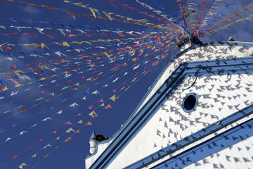 Colonial church adorned with colorful flags