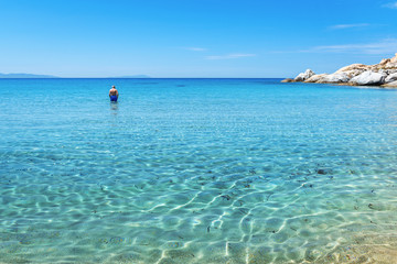 NAXOS, GREECE: May 24, 2017: Crystal blue waters on Mikri Vigla beach on Naxos island, one of the most beautiful beaches of the Aegean Sea. Cyclades, Greece