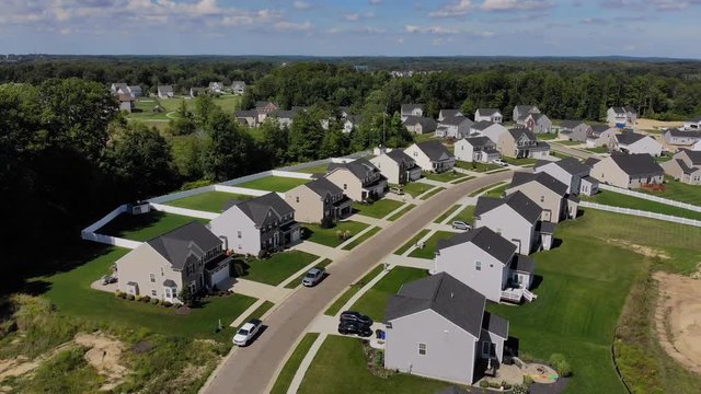 An aerial reverse establishing shot of a typical Ohio neighborhood on a summer day. Cleveland suburbs.  	
