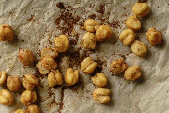 Roasted chickpeas with paprika, salt and spices on baking paper sheet and linen