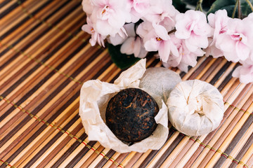 Chinese tea Pu Erh in a block with a paper wrapper with flowers