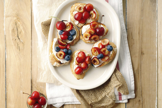Bruschetta with cherry, blueberry, honey sauce and cream cheese