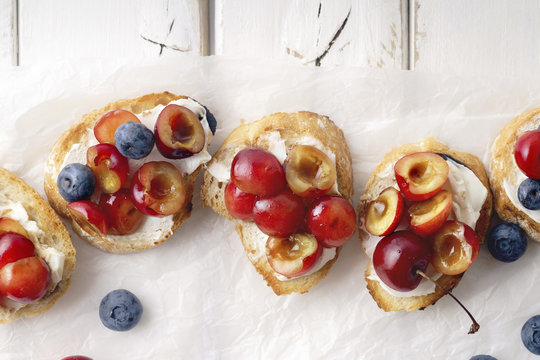 Bruschetta with cherry, blueberry, honey sauce and cream cheese