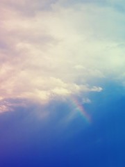 Naklejka na ściany i meble Beautiful rainbow with cloudy sky background.