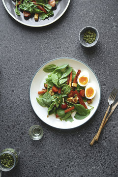Overhead shot of fresh salad with fried cheese, roasted carrot, cherry tomatoes and pumpkin seeds
