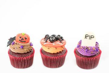 Variety of Halloween cupcakes on white