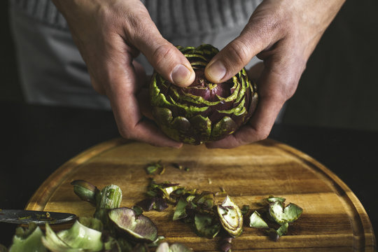 A man preparing an artichoke