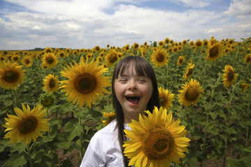 Little girl in sunflowers field - 220657512