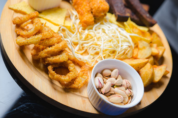 assorted snacks for beer: pistachios, toasts, onion rings cheese