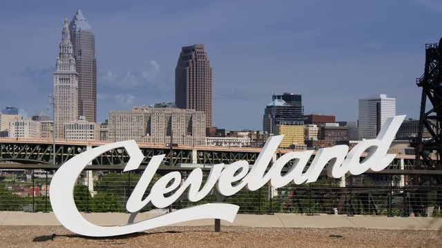 CLEVELAND, OH - Circa September, 2018 - A daytime summer establishing shot of the Cleveland script sign with the city skyline in the distance.  	