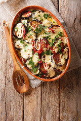Vegetable casserole from eggplants with tomatoes and mozzarella cheese and parmesan close-up. Vertical top view