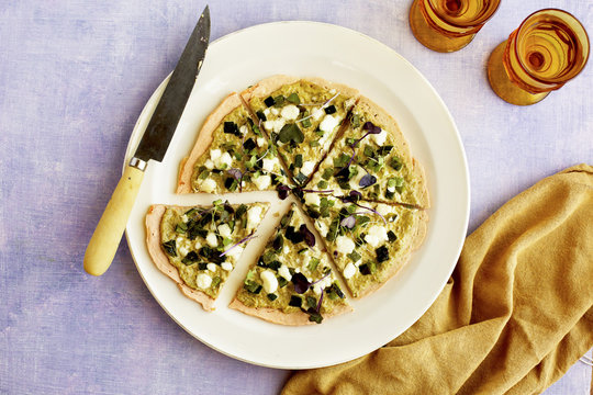 Red Lentil Flatbread with Roasted Poblano Tomatillo Pesto. Photographed on a lilac background.