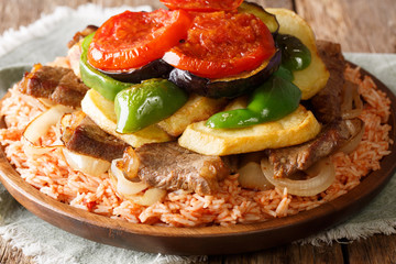 Tasty Lebanese recipe maklouba: rice with beef, eggplant, pepper, onions and tomatoes close-up. horizontal