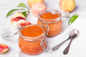Homemade peach jam with organic fruit. Sweet preserves on a light background