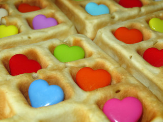 Belgian waffles decorated with colorful love hearts. Romantic breakfast close-up