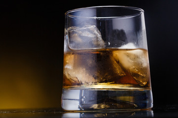 a glass with whiskey and ice on a background - 220661105