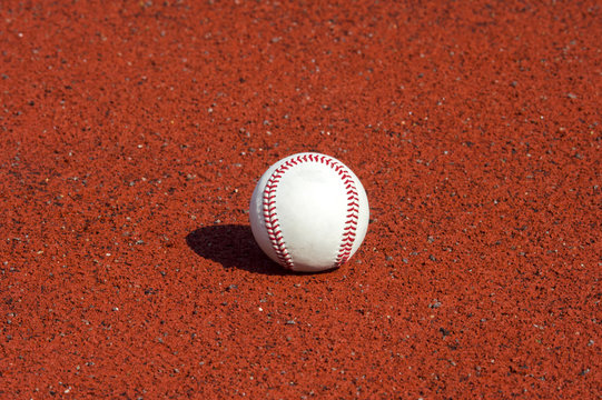 new baseball ball on red track rubber