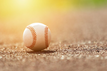 Baseball ball on pitchers mound. Baseball field at sunset