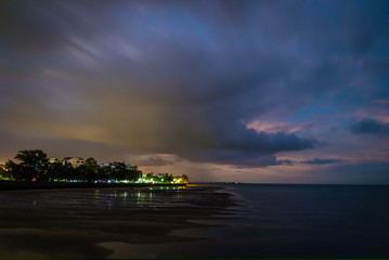 Urangan at night with lights on and red clouds