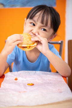 Asian Chinese little girl eating burger