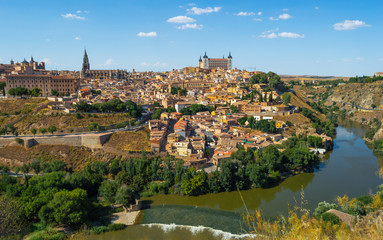 Fototapeta na wymiar Skyline of Toledo, beautiful city of Spain. Sunny landscape with view of the main monuments and Tagus river. Panoramic of Toledo, Castilla-La Mancha.